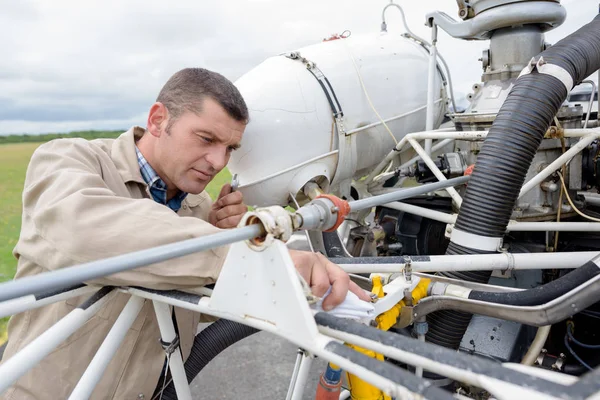 Mechanic is fixing airplane outdoors — Stock Photo, Image