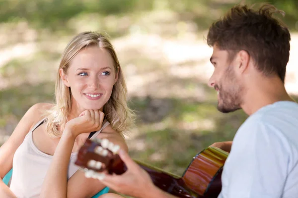 Man spela gitarr till flickvän — Stockfoto