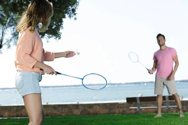 Mladý pár hrát badminton venku — Stock fotografie
