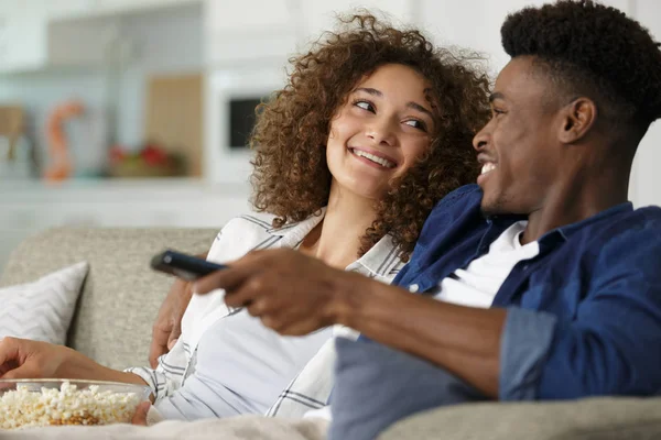 Junges Paar schaut auf dem Sofa fern — Stockfoto