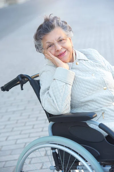 Пожилая женщина на улице в инвалидном кресле — стоковое фото