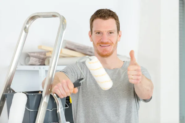 Man worker is holding paint brushes — Stock Photo, Image
