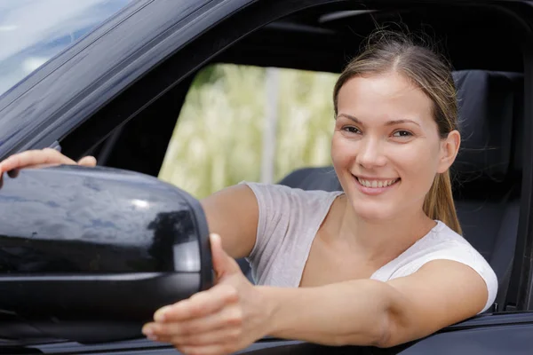 Junge Frau montiert Auto-Seitenspiegel — Stockfoto