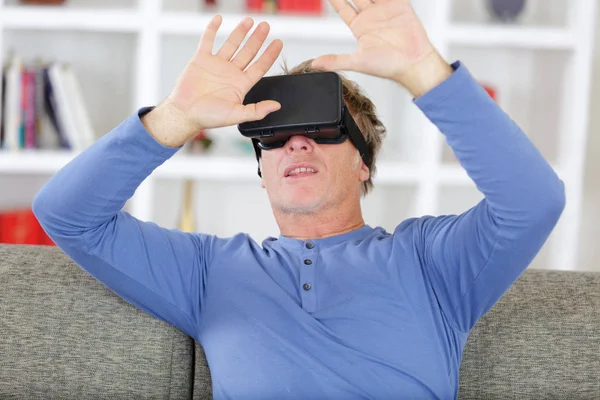 Scared man taking off virtual reality headset — Stock Photo, Image