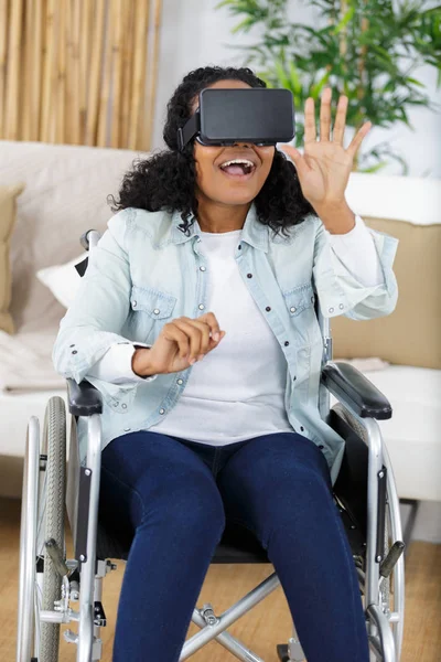 Kvinna i rullstol med hjälp av en virtuell verklighet mask — Stockfoto