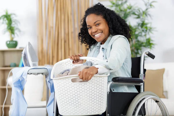 Lycklig kvinna på rullstol under strykning — Stockfoto