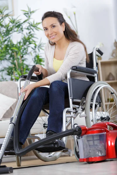 Felice donna disabile utilizzando un aspirapolvere — Foto Stock
