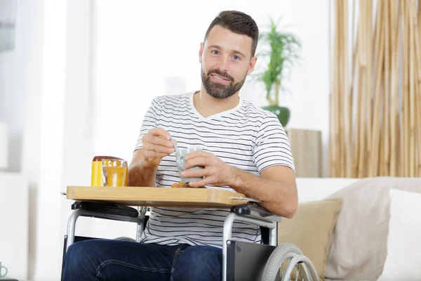 Jonge gehandicapte gewonde man ontbijten — Stockfoto