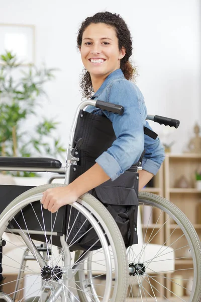 Glad ung funktionshindrad kvinna i rullstol hemma — Stockfoto