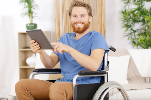 Uomo d'affari in sedia a rotelle con tablet nel suo ufficio — Foto Stock
