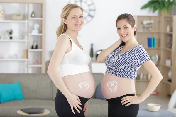 Pregnant women with heart shape stretch mark cream belly — Stock Photo, Image