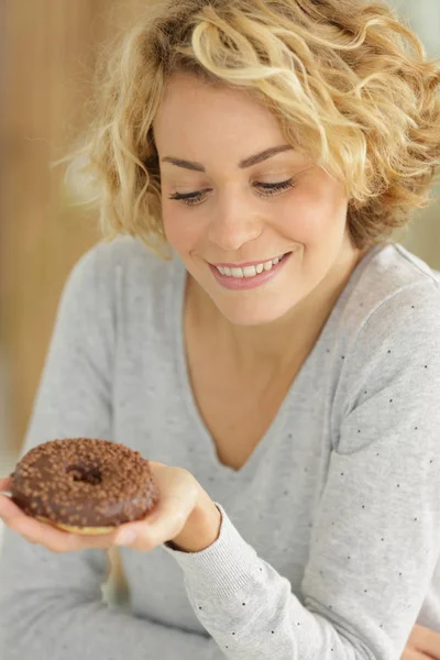 Молода жінка тримає пончик — стокове фото