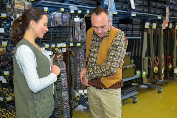Cliente masculino examinando abrigos en una tienda —  Fotos de Stock