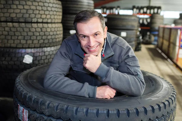 Automechaniker hält einen Reifen — Stockfoto
