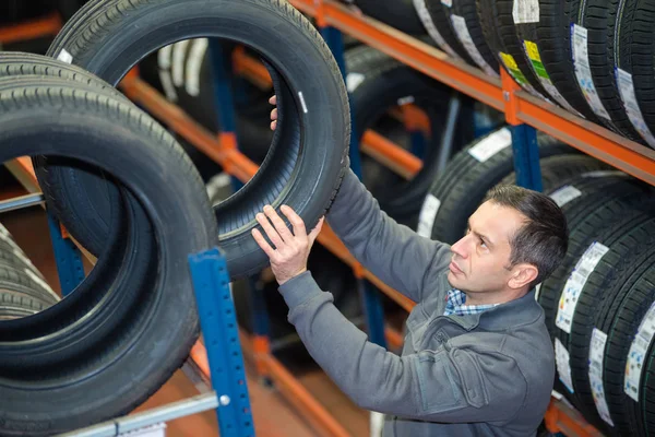 Automechaniker suchen sich eine Reifengröße aus — Stockfoto