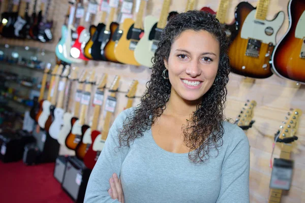 Portret van een lachende vrouw in de gitaarwinkel — Stockfoto