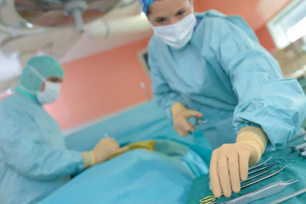 Operatore medico che raggiunge lo strumento durante il funzionamento — Foto Stock