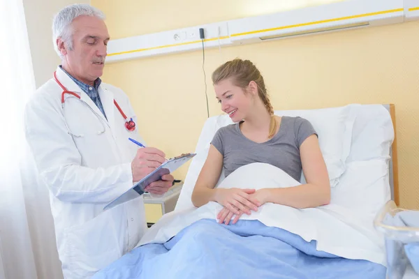 Пацієнт у лікарняному ліжку посміхається — стокове фото