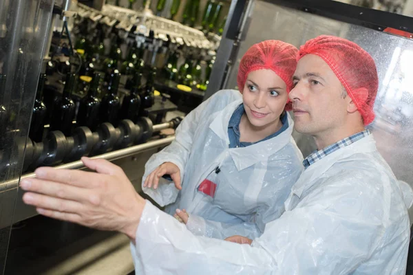 Científicos que usan bata de laboratorio y red para el cabello en la fábrica — Foto de Stock