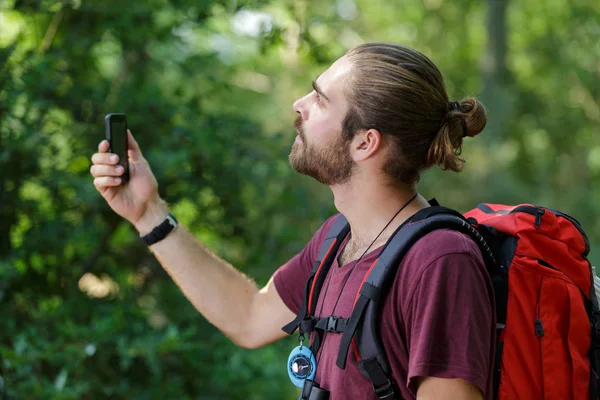 Mannelijke wandelaar is op zoek naar zijn telefoon — Stockfoto