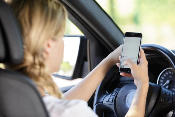 Une femme envoyant un texto en conduisant — Photo