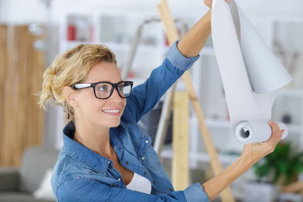 Mujer joven con rollo de papel pintado —  Fotos de Stock