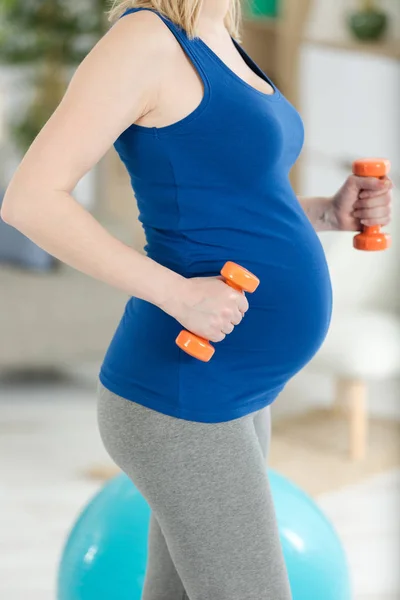 Fitness en yoga oefeningen met dumbbels voor zwangere vrouw — Stockfoto