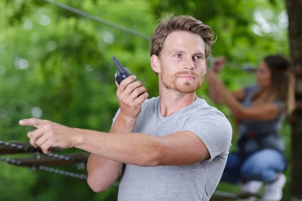 Homem no parque de cordas usando um walkie talkie — Fotografia de Stock