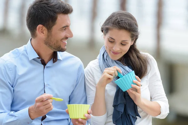 Koppel zat buiten ijs te eten — Stockfoto