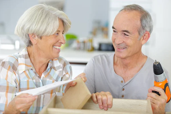 Senior couple hanging a picture frame on the wall — Stock Photo, Image