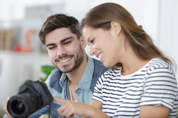 Couple heureux avec caméra assis sur le canapé — Photo