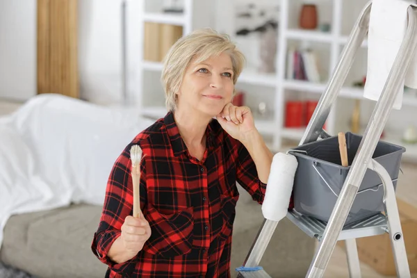 Donna anziana come pittrice di fronte a sfondo bianco — Foto Stock