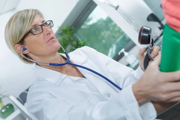 Lékař vyšetřuje krevní tlak staršímu pacientovi — Stock fotografie