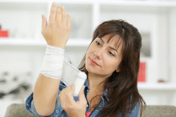 A woman bandaging her wrist — Stock Photo, Image