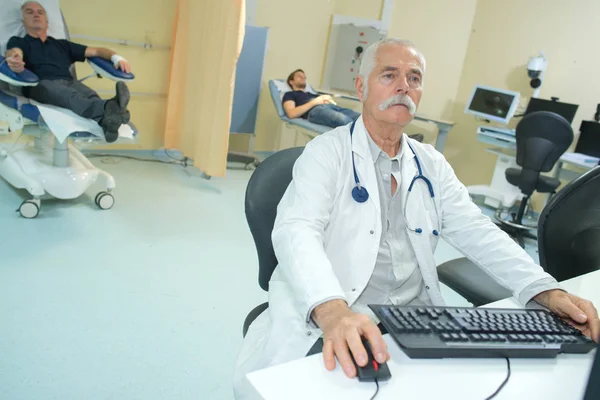 Doctor masculino agregando registros en una computadora en una clínica — Foto de Stock