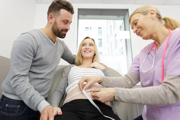 Positiv gynekolog tar mätning av baby bump — Stockfoto