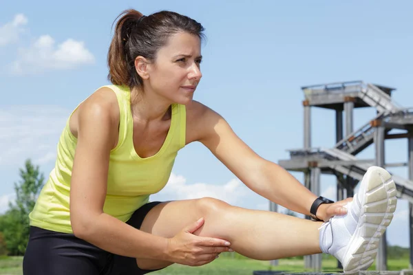 Mujer activa estira las piernas al aire libre — Foto de Stock