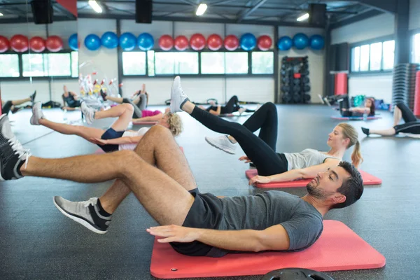 People working out on mats in gym — Stock Photo, Image