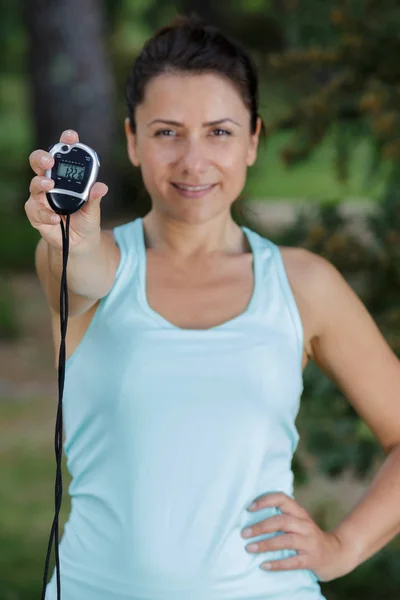 Mulher feliz mostrando cronômetro ao ar livre — Fotografia de Stock