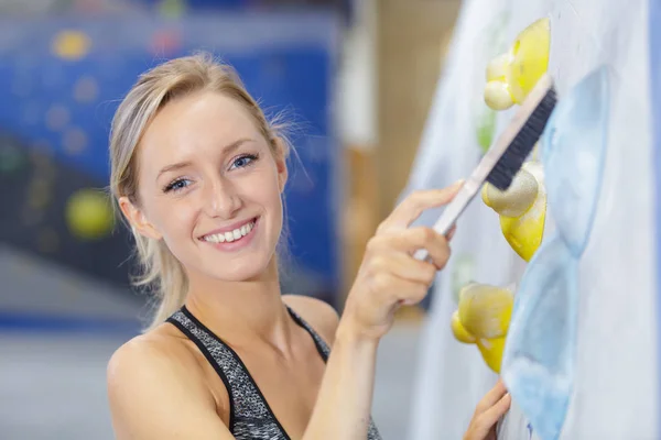 Szczęśliwa młoda kobieta sprzątanie ścianki wspinaczkowej — Zdjęcie stockowe