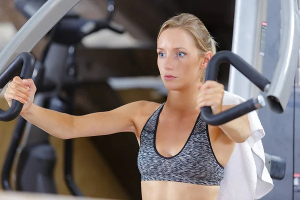 Женщина делает упражнения для рук в тренажерном зале — стоковое фото