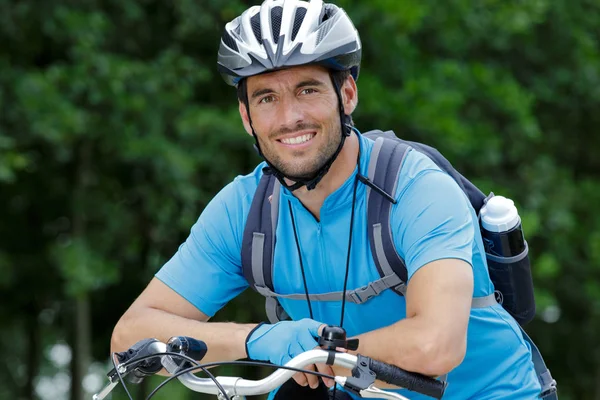 Retrato do ciclista masculino apoiando-se no guidão — Fotografia de Stock