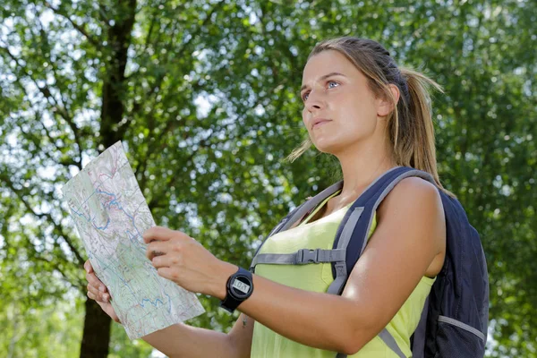 Sırt çantasındaki genç kadın haritasını kontrol ediyor — Stok fotoğraf