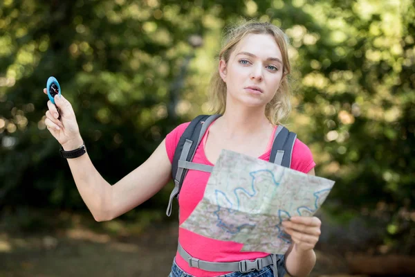 Retrato de una joven excursionista sosteniendo brújula y mapa —  Fotos de Stock