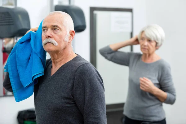 Älterer Mann wischt sich mit blauem Handtuch die Haare — Stockfoto