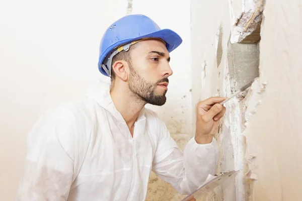 Hombre constructor supervisando la pared —  Fotos de Stock