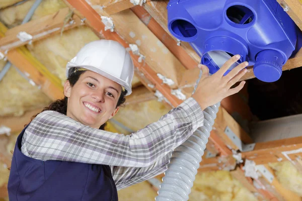 Ženský stavitel pracující ve ventilační místnosti — Stock fotografie