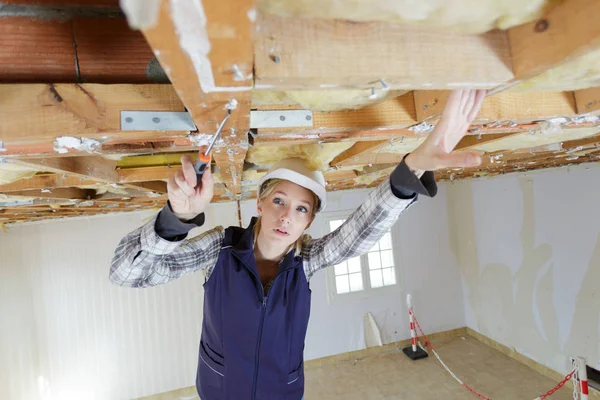 Young woman pulling to the ceiling in repair loft apartment — Stock Photo, Image