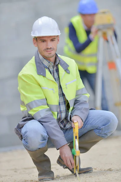 Les constructeurs utilisent pour mesurer la hauteur du ciment — Photo