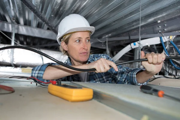 Eletricista fêmea instalar ventilação no teto — Fotografia de Stock